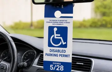 A disabled parking placard hanging from a car’s mirror